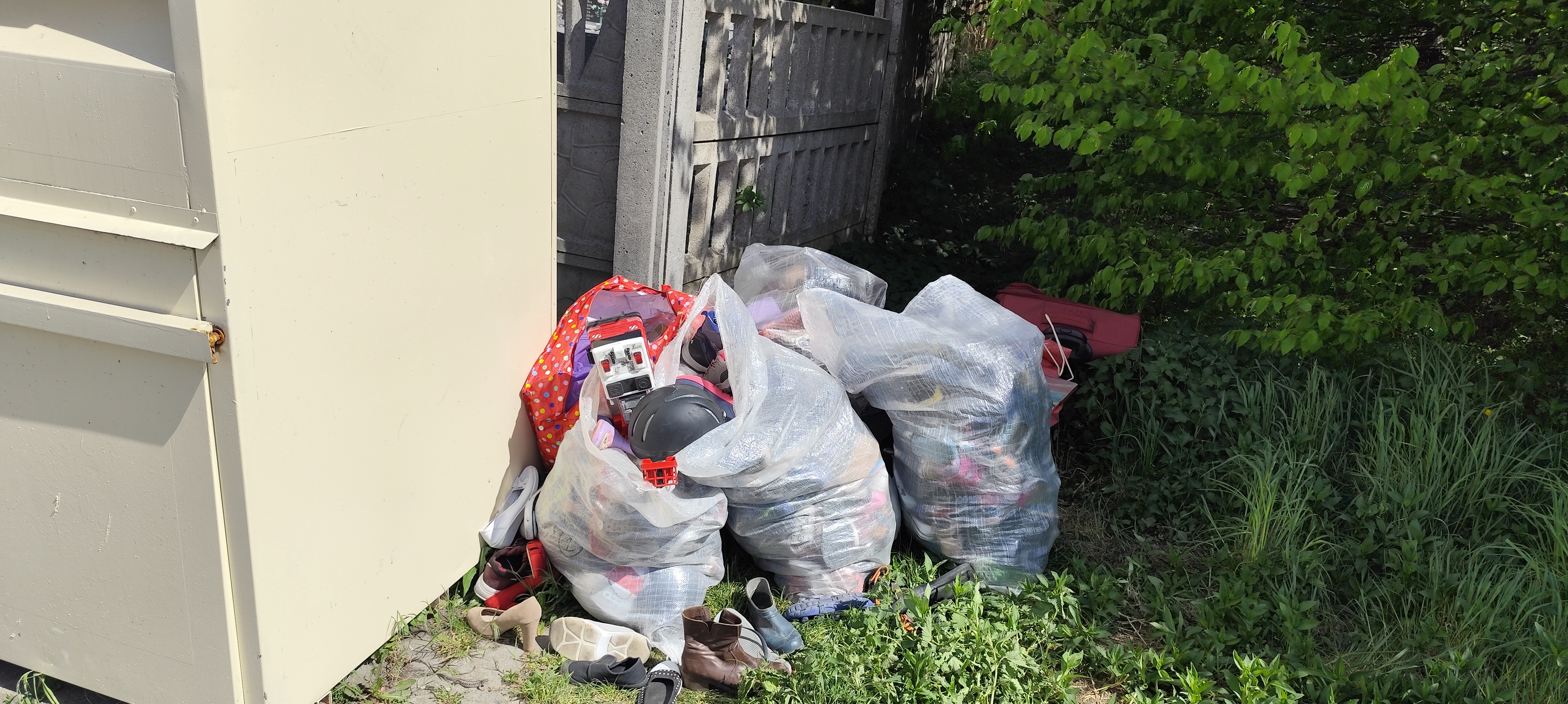 Kontener przy którym ustawiono worki z ubraniami ujęcie 1